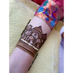 A close up of an elephant motif on an armband. This design shows a royal elephant with a decorative covering, set against a backdrop of a palace structure.