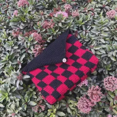 My checkerboard book sleeve in red and black. It has a flap and a button to make sure your book stays protected.