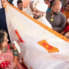 A key moment in a Gujarati wedding, the 'Antarpat' cloth is lowered, and the couple sees each other for the first time at the mandap.