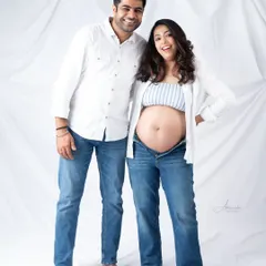 Pure happiness. This fun, casual portrait of an expecting couple in matching white shirts and jeans is full of energy and laughter.