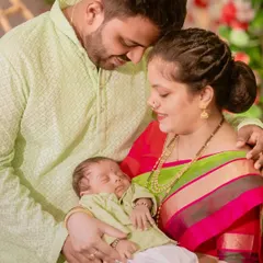 A loving family portrait from a newborn naming ceremony. The parents gaze adoringly at their sleeping baby, a moment of pure love and tenderness.
