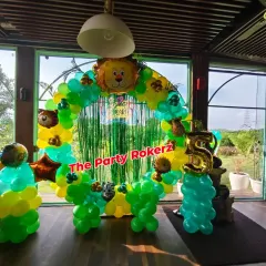 This jungle theme was set up in a restaurant with a beautiful green view. The balloon arch with animal faces and a large number '5' foil balloon perfectly framed the outdoor scenery.