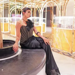 The full silhouette of the black Nexus pre-stitched sari, showcasing its fluid drape and the sharp structure of the zari threadwork corset.