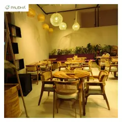 This is a view of a cafe interior I designed. The combination of natural wood furniture, rattan chairs, and clusters of hanging woven lamps creates a warm, earthy, and inviting experience for diners.