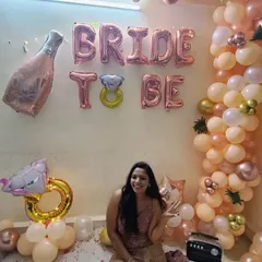 The happy bride-to-be enjoying her party in the decorated space we created for her at home.