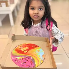 This little cutie is ready to take home her very first fluid art masterpiece, a colorful circular piece. We even provide pizza boxes for safe and easy transport of wet canvases.