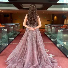 A full back view of this princess-inspired hairstyle. The length is full of bouncy curls, creating a dramatic and glamorous effect that looks stunning with a gown.