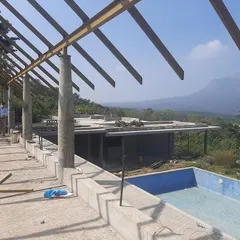 The skeletal roof structure of the hotel begins to take shape, revealing the open, airy design that will eventually shelter the main terrace and pool.