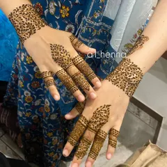 This design features leafy cuffs on the wrists and detailed finger work, offering a modern and chic alternative to full-hand henna.