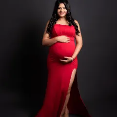 The classic red maternity gown. This bold color symbolizes love and strength, and the sleek, fitted design with a side slit is both elegant and modern.