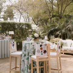 A high-top table at a luncheon, with custom-printed fabric on the chair backs. These small details add a layer of bespoke design that makes the event feel truly unique.