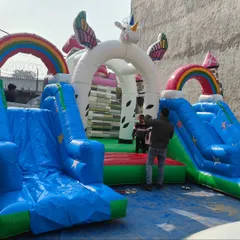 A magical unicorn-themed bouncy castle with rainbows, wings, and two slides. This is a very popular design for girls' birthday parties and fantasy-themed events.