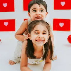 A fun and playful pose during a sibling photoshoot. This image perfectly captures the energy and joy of childhood.