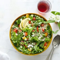A vibrant top-down shot of a healthy quinoa salad in a yellow bowl. Flat-lay food photography like this is perfect for menus, blogs, and social media, showcasing all the fresh ingredients at once.