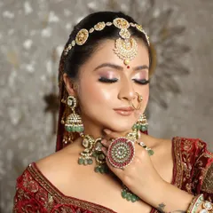 A truly regal bride. This look features a stunning matha patti and intricate jewelry, paired with soft pink eyeshadow and a defined eye to create a majestic yet gentle appearance.