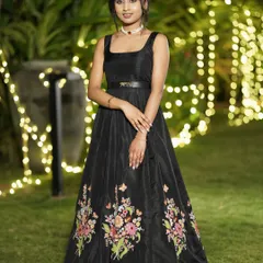 For the modern woman who loves a touch of drama, I designed this bespoke black Indo-Western gown. The fitted bodice flows into a full skirt, brought to life with vibrant, hand-embroidered floral motifs. It's a unique statement piece, ideal for a reception or cocktail evening.