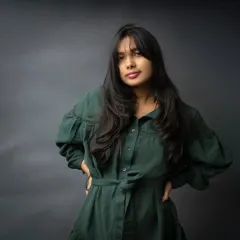 A confident and direct portrait against a classic moody backdrop. Her pose and direct gaze convey a quiet strength, making for a powerful and engaging image.