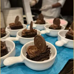 Rich chocolate cake bites topped with a swirl of chocolate frosting and a chocolate disk. Served in individual handled bowls, these mini desserts are perfect for easy, elegant indulgence.