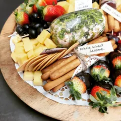 Our gourmet cheese platter is perfect for any special occasion, featuring our homemade herb-crusted cheese log, assorted cheese cubes, fresh strawberries dipped in chocolate, and a variety of crackers.