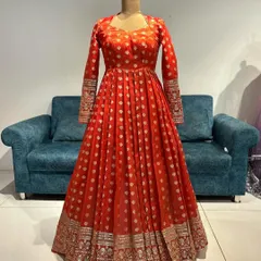 The front view of the red Banarasi Anarkali gown, with its rich fabric and elegant full sleeves.