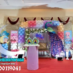 A grand baby shower in a hall featuring a large peacock, a crescent moon photo prop, and multiple balloon pillars. This setup shows how I can fill a large stage with many fun and colorful elements.