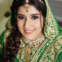 Radiance in green for the stunning Sunaina. This look embraces tradition with a touch of modern elegance, featuring a soft smokey eye and a flawless complexion that enhances her bridal glow.
