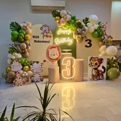 Another angle of the stylish 'Wild Mohammed' jungle theme party decor, showing the reflection of the neon sign and marquee number on the glossy floor.