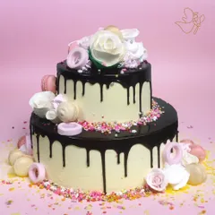 A decadent two-tier chocolate drip cake, perfect for making any birthday or anniversary unforgettable. It's beautifully adorned with delicate roses, macarons, and colorful sprinkles for a touch of fun.
