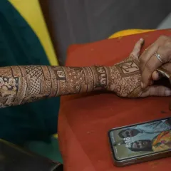 A candid shot of me working on an intricate arm design. You can see the reference photo on the phone, ensuring the personalized elements are perfect.