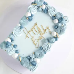 This rectangular sheet cake was for a 60th birthday, decorated in a beautiful blue ombre. The border is piped with intricate swirls and rosettes, creating a simple yet stunning celebration cake.