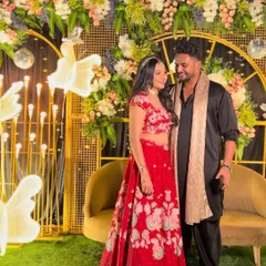 A lovely photo of the couple against the modern gold and floral backdrop, capturing the happy atmosphere of their Sangeet celebration.