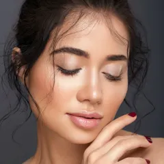 A serene portrait with eyes closed, emphasizing the soft, neutral eyeshadow and the perfectly groomed brows. The pose is calm and contemplative, highlighting the elegance of a minimalist look.