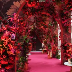 Who says an entrance can't be the main event? I designed this passionate, red-on-red floral tunnel to create a dramatic and immersive first impression. The layered arches and dense crimson blooms guide guests into a world of warmth and bold elegance, setting an unapologetically glamorous tone for the evening.
