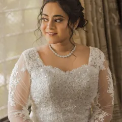 A lovely portrait of Steffi by the window. The natural light highlights her soft makeup and the intricate lace details of her gown.