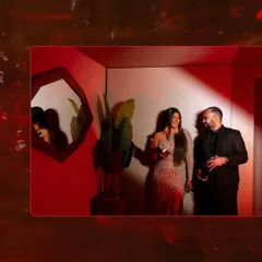 An artistic shot of a couple at their cocktail party, framed by red light trails, capturing the vibrant and energetic mood.