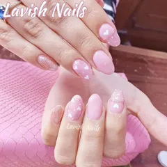 A sweet and simple design with soft pink polish and accent nails featuring a delicate pattern of tiny white hearts.