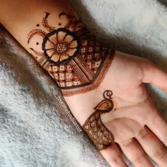 A creative and minimal design featuring a floral cuff at the wrist and a single peacock motif on the index finger.
