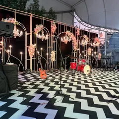 Another view of the stage, ready for the band to perform. The combination of the modern geometric floor, classic chandeliers, and professional audio setup created the perfect party ambiance.