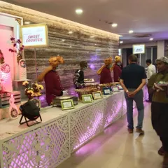A view of our sweet counter and main course line at a wedding reception. The clear signage and organized layout ensure a smooth experience for all guests.
