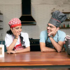 A fun and playful shot from a chef-themed pre-wedding session. This concept allows couples to interact naturally and create unique photos that reflect a shared hobby or simply their fun-loving personalities.