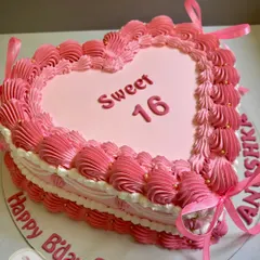 A pretty pink heart-shaped cake for a Sweet 16 celebration. I used delicate piping techniques to create an ombre effect and finished it with ribbons and gold pearls.
