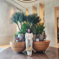 Komal, all smiles, posing with our latest plant installation. This beautiful arrangement of varied plants in wooden bowl planters is a perfect example of the lush, multi-layered look we love to create.