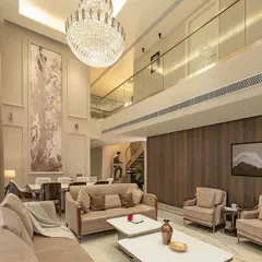 In our neoclassical projects, we balance classical opulence with modern living. This double-height drawing room features towering ceilings and refined detailing, anchored by a magnificent crystal chandelier that defines the space.