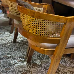 Another view of the cane chairs, showing the beautiful curvature of the backrest and the quality of the weaving. This design is timeless and adds a warm, inviting feel to any space.