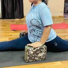 A close-up of using blocks in a split variation. This technique allows the practitioner to control the depth of the stretch and build confidence in the pose.