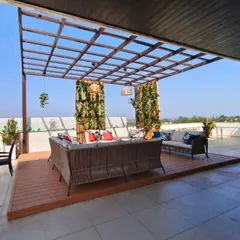 Another view of the expansive glass pergola at Swiss Town, showcasing the comfortable wicker lounge set and the open, airy feel of the space. This is a prime example of how we create functional and beautiful outdoor living rooms.