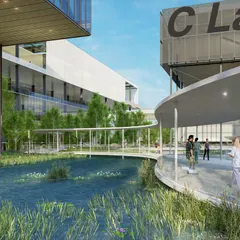 The curving walkways at the Amara Raja campus are designed to create a fluid journey through the landscape. This perspective highlights the C Lab building and the seamless connection between the research facilities, green spaces, and water features, fostering a campus for cutting-edge science.