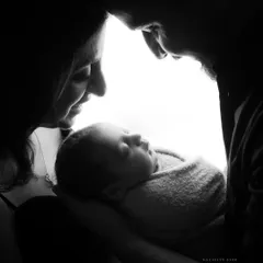 There is something magical about the first few days with your newborn. This artistic black and white silhouette captures the profound love and connection of new parents holding their baby.
