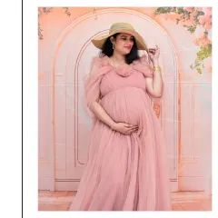A stylish portrait featuring a lovely pink tulle gown and a chic straw hat. The floral backdrop adds a touch of romance, creating a look that is both sweet and fashionable.