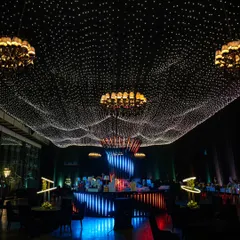 We transformed an indoor venue into a celestial wonderland with a custom starlit ceiling. This immersive lighting installation, combined with elegant chandeliers, creates a magical atmosphere perfect for gala dinners and milestone celebrations.